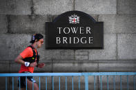 A runner is seen on Tower Bridge on the day that would have been the London Marathon, which has been postponed due to the coronavirus outbreak, in London, Sunday, April 26, 2020.(AP Photo/Alberto Pezzali)