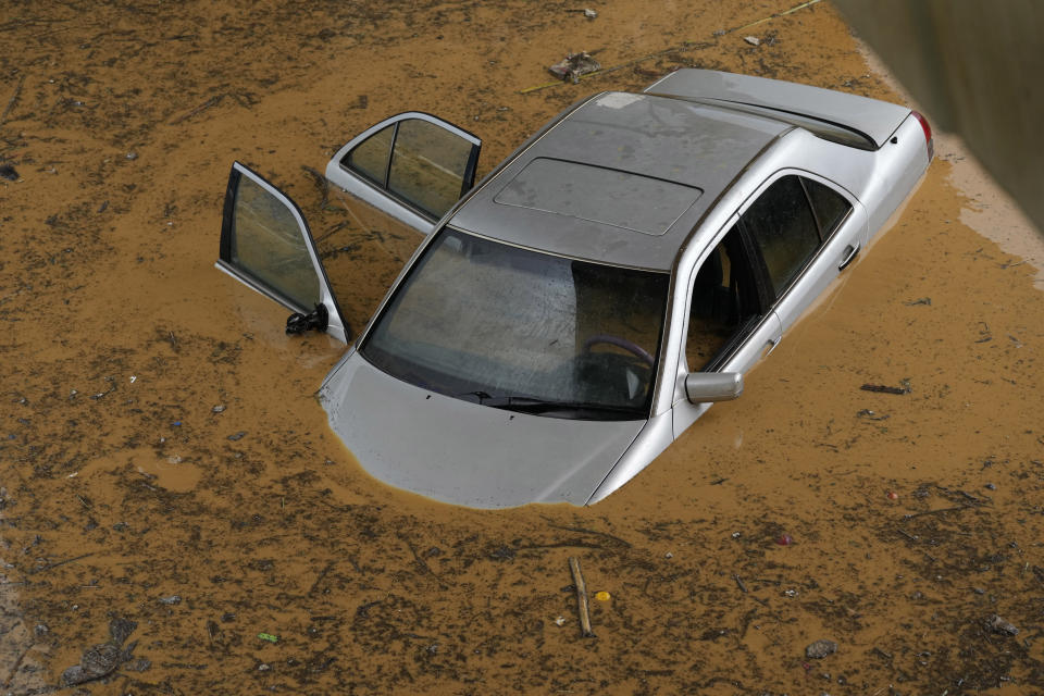 A car is submerged in flood water at a highway flooded by the rains, in Beirut, Lebanon, Saturday, Dec. 23, 2023. A rainstorm has paralysed parts of Lebanon's cities, turning streets to small rivers, stranding motorists inside their vehicles and damaging homes in some areas. (AP Photo/Hussein Malla)