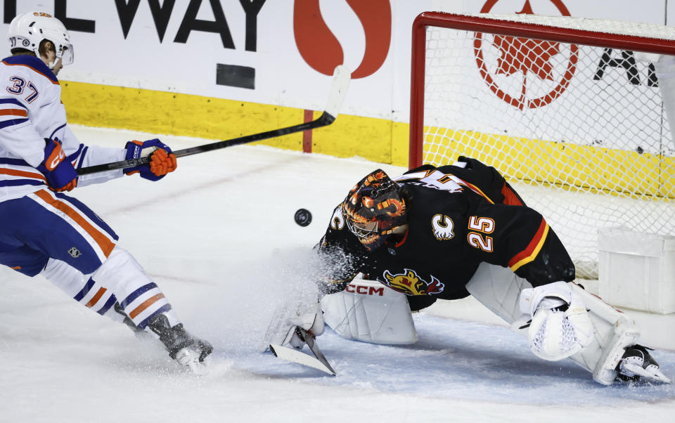 Edmonton Oilers forward Warren Foegele (37) has his shot deflected by Calgary Flames goalie Jacob Markstrom (25) during the first period of an NHL hockey game Saturday, April 6, 2024, in Calgary, Alberta. (Jeff McIntosh/The Canadian Press via AP)
