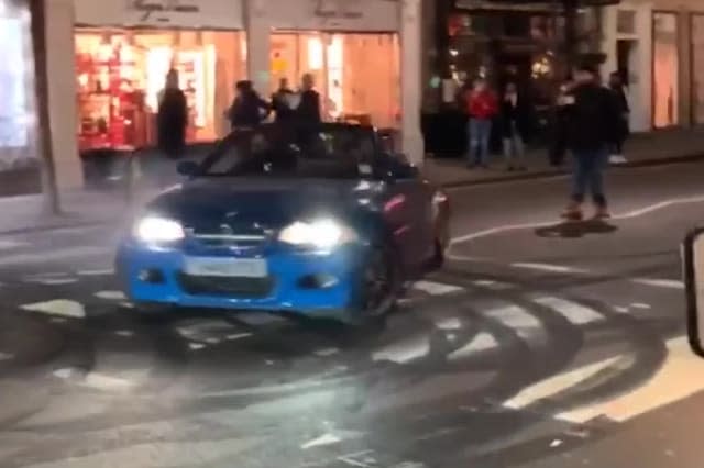 Footage shows a number of expensive cars performing 'doughnuts', leaving tyre marks and speeding