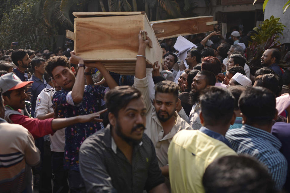 Bangladeshis carry coffins of relatives out from a morgue after they were killed in a fire in Dhaka, Bangladesh, Thursday, Feb. 21, 2019. A devastating fire raced through at least five buildings in an old part of Bangladesh's capital and killed scores of people. (AP Photo/Mahmud Hossain Opu )