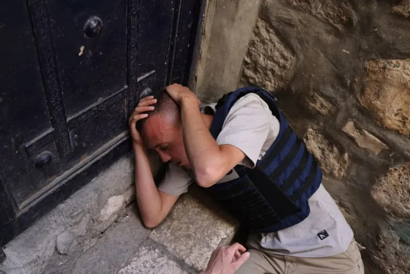 Palestinian journalist Saif Kwasmi holds his head after Israeli right-wing activists attacked him during a march to commemorate Jerusalem Day. Ilia Yefimovich/dpa