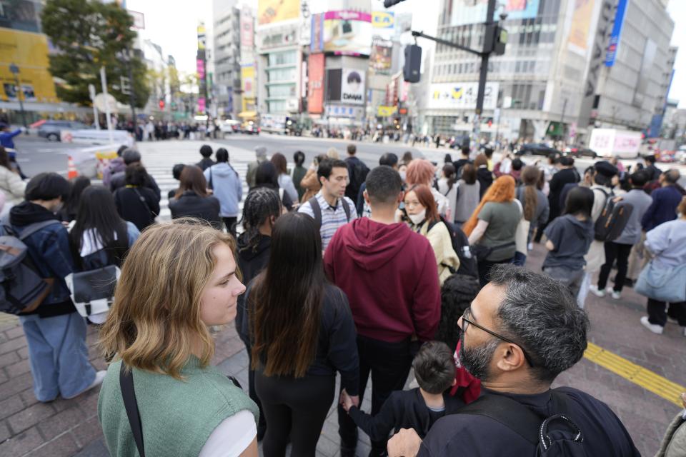 Frank Striegl, center, a guide of Tokyo Ramen Tours, leads several participants of a ramen tasting tour near Shibuya pedestrian crossing at Shibuya district on April 2, 2024, in Tokyo. (AP Photo/Eugene Hoshiko)