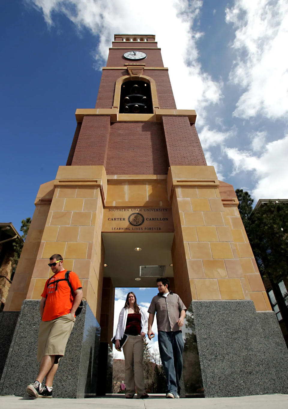 Students pass beneath the clock tower at Southern Utah University.