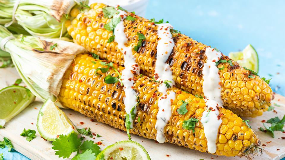 Ears of grilled corn as part of a guide on how to grill it