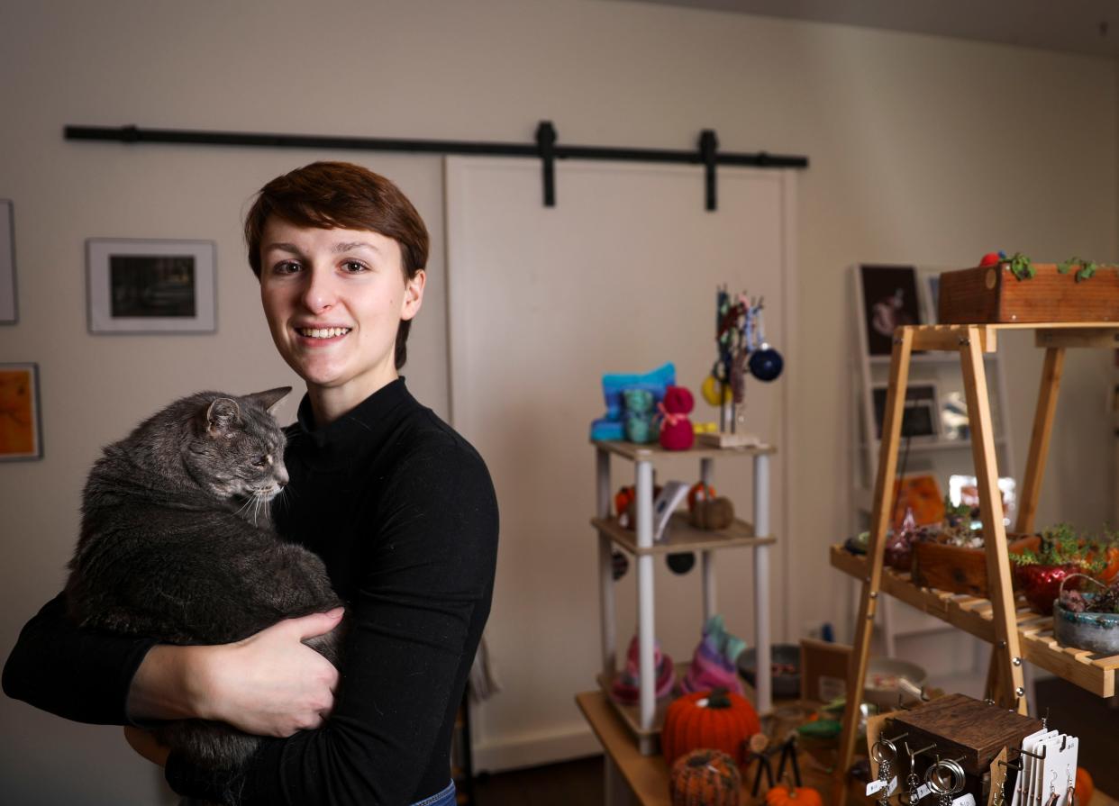 Emily Samuelian, owner of The Little Pumpkin Cat Cafe, with shop cat Saturn on Dec. 1 in Independence. Samuelian created the space to combine her love of trinkets and cats.