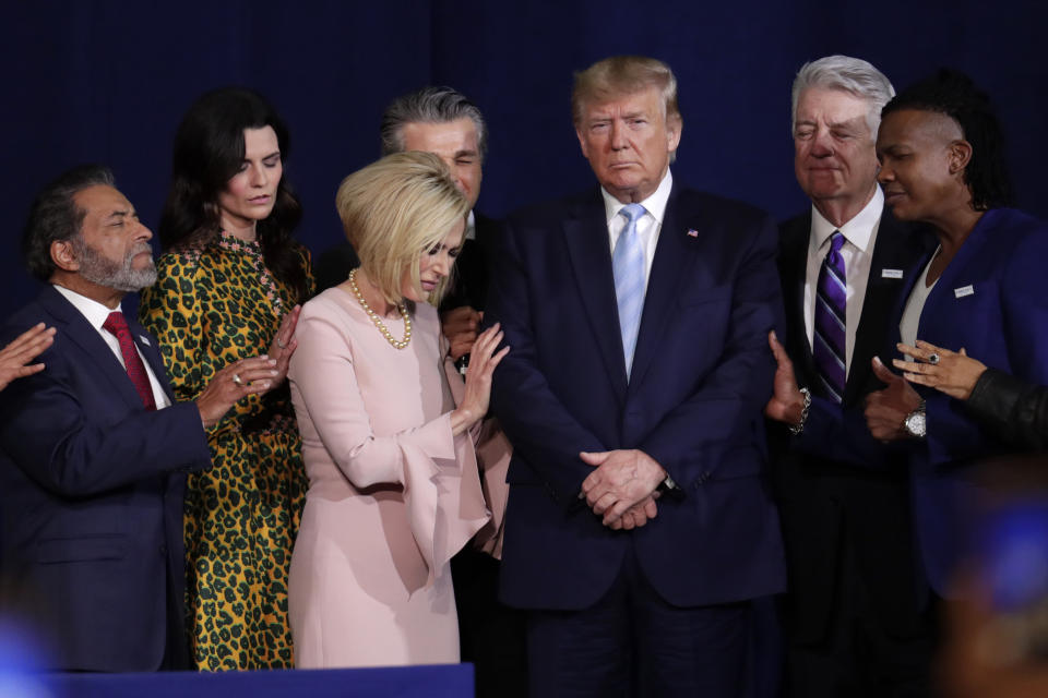 FILE - In this Jan. 3, 2020, file photo, faith leaders pray with President Donald Trump during a rally for evangelical supporters at the King Jesus International Ministry church in Miami. On Friday, March 5, 2021, The Associated Press reported on a manipulated version of this photo circulating online depicting the people praying over a golden idol of former President Donald Trump. While numerous attendees of this year’s Conservative Political Action Conference in Orlando, Florida, posed for selfies with a 6-foot-tall golden statue of Trump, the original photo was made over a year earlier. (AP Photo/Lynne Sladky, File)