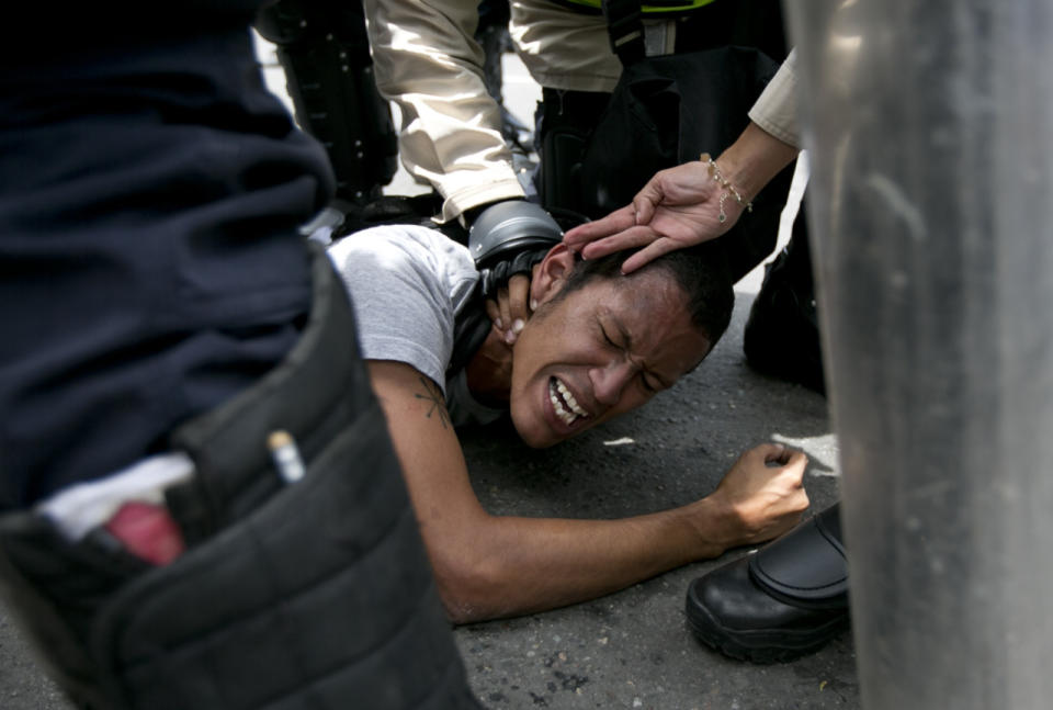 Un manifestante es reprimido por la policía venezolana durante la protesta para solicitar un referendum revocatorio del presidente Nicolás Maduro en Caracas este 16 de mayo de 2016. (AP Photo/Ariana Cubillos)