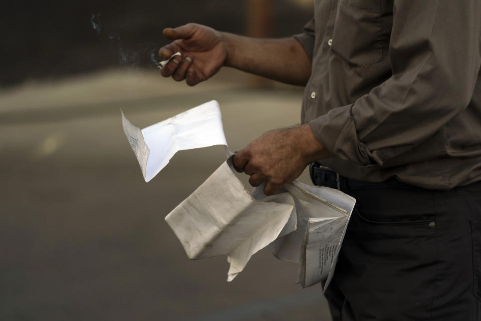 Student driver Mohammad Kiani, 54, holds a cigaret while going over a pre-trip inspection before getting on a practice truck at California Truck Driving Academy in Inglewood, Calif., Wednesday, Nov. 17, 2021. (AP Photo/Jae C. Hong)