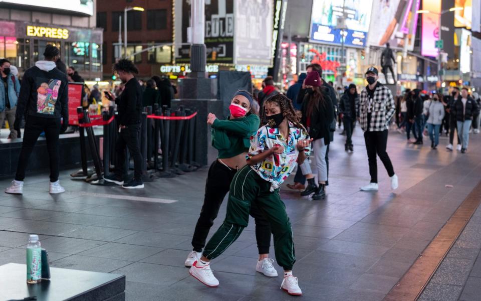 Two girls wearing masks record a 'TikTok' in Times Square  - Alexi Rosenfeld /Getty Images North America 