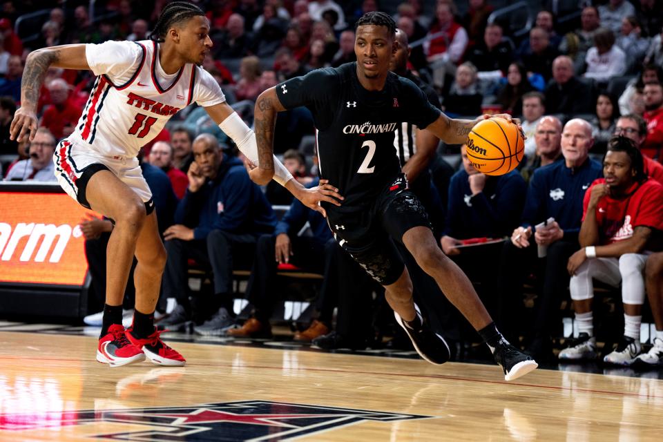 Cincinnati Bearcats guard Landers Nolley II (2) drives on Detroit Mercy Titans forward Gerald Liddell (11) in the first half of the NCAA men’s basketball game between the Cincinnati Bearcats and Detroit Mercy at Fifth Third Arena in Cincinnati on Wednesday, Dec. 21, 2022. 