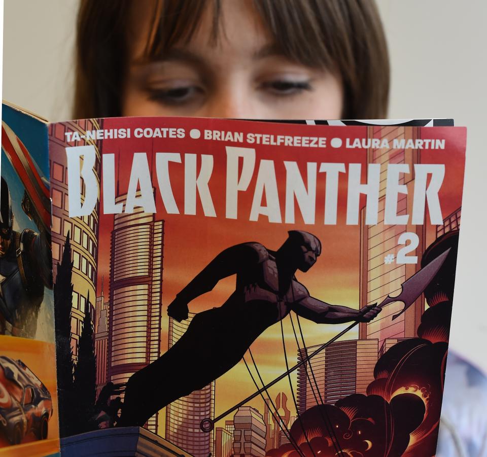 In this photo illustration a woman reads a copy of the Black Panther (T'Challa) a fictional superhero appearing in comic book published by Marvel Comics in New York May 17, 2016. Captain America and Iron Man may be the stars of Marvel's latest comic-book blockbuster, but Black Panther -- making his big-screen debut -- is most definitely the superhero of the moment. Black Panther, the warrior king of the futuristic fictional African country Wakanda, is starring in a new comic book series that is doing booming sales, and will be the first black hero to get a standalone film, in 2018. The new comic series -- written by acclaimed author Ta-Nehisi Coates, a leading voice on race issues in America -- debuted in April, and so far 330,000 copies of the first issue alone have been sold, according to Marvel.  / AFP / TIMOTHY A. CLARY / TO GO WITH AFP STORY BY THOMAS URBAIN-"Black Panther, Marvel's African hero, in the spotlight"        (Photo credit should read TIMOTHY A. CLARY/AFP via Getty Images)