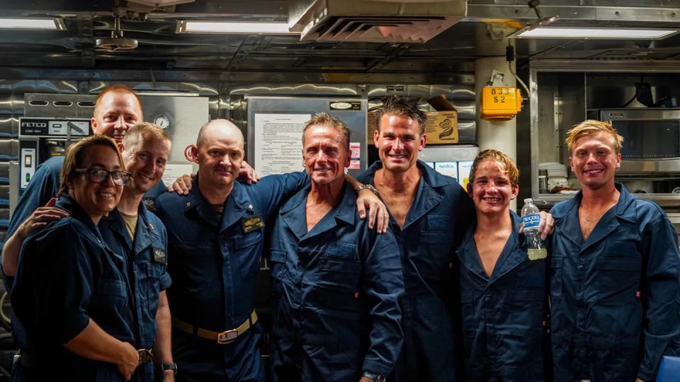 Sailors assigned to guided-missile destroyer Porter pose with Ben Wiggins, Daniel Williams, Evan Williams, and Luke Lodge after rescuing the divers at sea off the coast of Wilmington, N.C.  (Interior Communications Electrician 3rd Class Hailey A. Servedio/U.S. Navy)