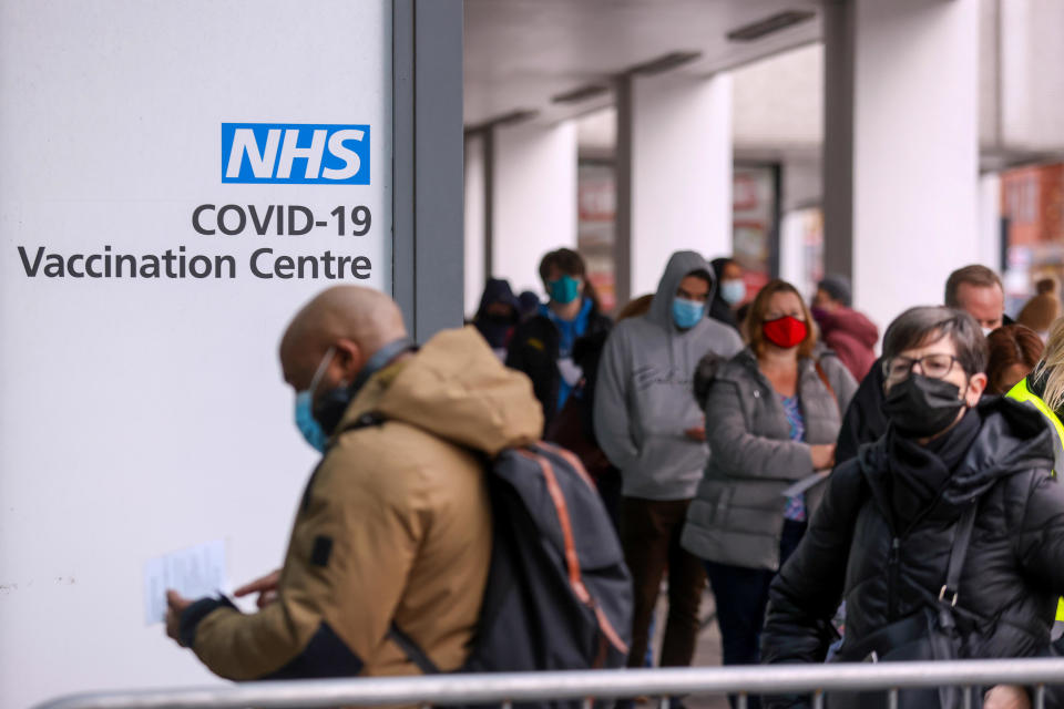 People line up for COVID-19 vaccinations at a National Health Service walk-in vaccine center at Romford, U.K., December 13, 2021.  / Credit: Chris Ratcliffe/Bloomberg via Getty