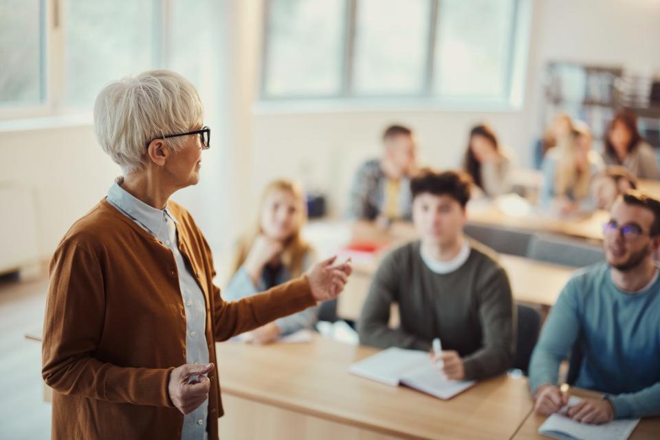 an older teacher teaching a class of high schoolers