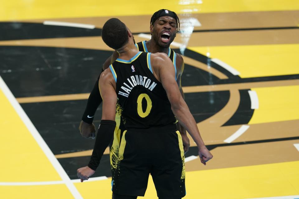 Tyrese Haliburton (0) y Buddy Hield, de los Pacers de Indiana, celebran durante la segunda mitad del juego de baloncesto de la NBA en el torneo In-Season en contra de los Celtics de Boston, el lunes 4 de diciembre de 2023, en Indianápolis. (AP Foto/Darron Cummings)