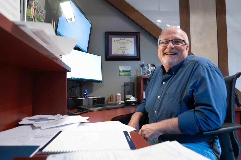 Thomas Underwood, NOTO Arts and Entertainment District executive director, smiles from his desk Thursday at the NOTO Arts Center.