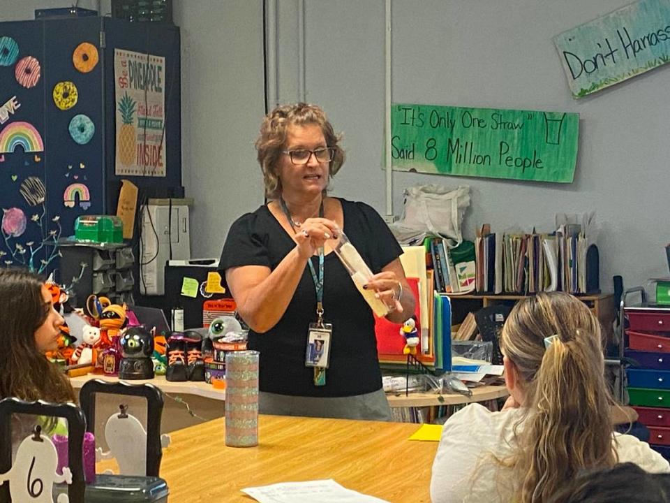 La maestra de Key Largo School Pamela Caputo mostrando a sus alumnos de quinto curso un paquete de palillos de plástico, popotes y una servilleta durante una clase sobre los Everglades el lunes 23 de septiembre de 2023.