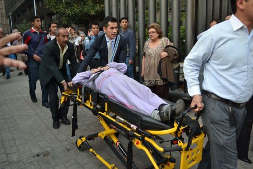 Trabajadores de Pemex sacan en camilla a una persona del edificio, el jueves 31 de enero en Ciudad de México. Al menos 25 personas murieron y otras 101 resultaron heridas en una explosión por causas desconocidas ocurrida en la sede central de la petrolera estatal Pemex, donde continúa la búsqueda de superviventes, informó el Gobierno mexicano. (AFP | str)