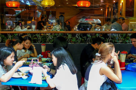 People eat their lunch at a street food shop in Bangkok, Thailand April 20, 2017. REUTERS/Athit Perawongmetha