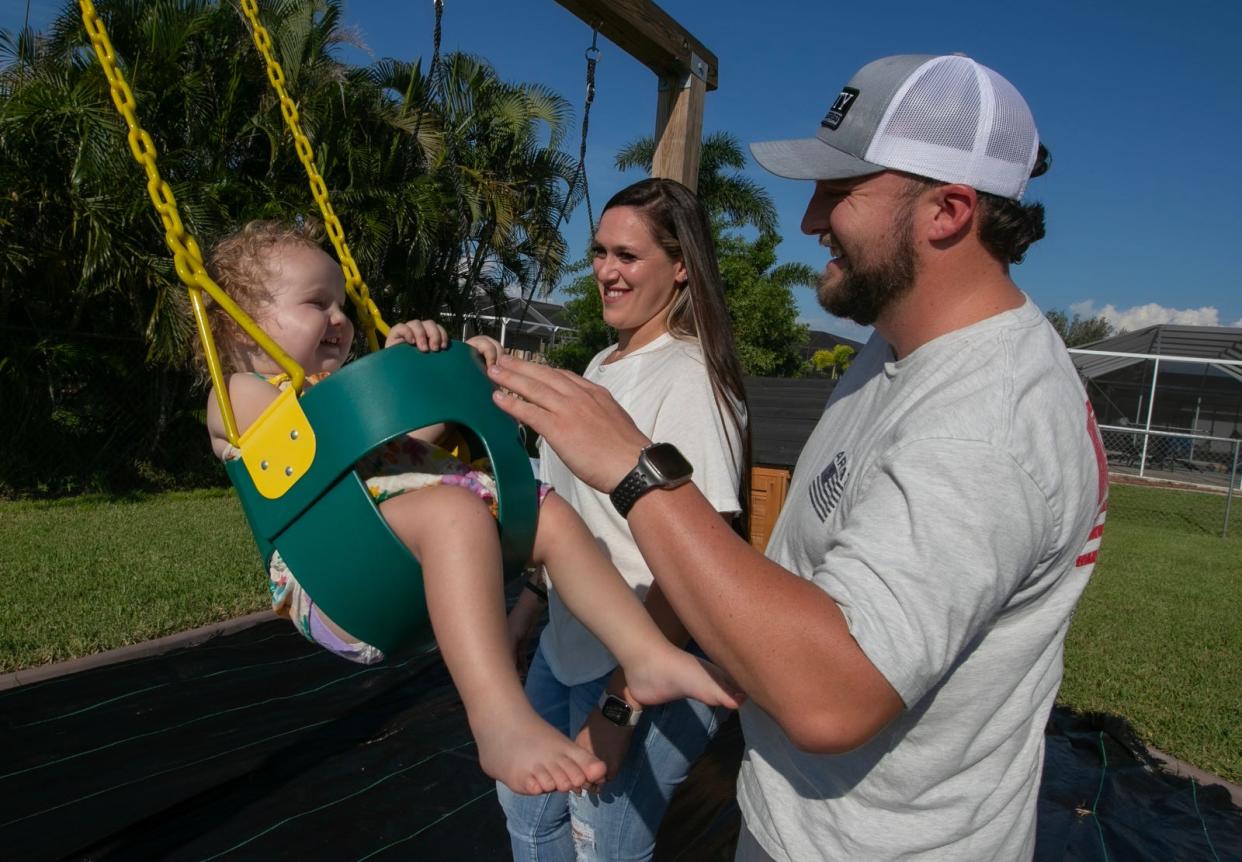 Cape Coral residents and police officers Nicholas Bezanson and Kelsey Meadows play in their backyard home swing set with their daughter Hayden Bezanson, 2, Wednesday, September 13, 2023. Ricardo Rolon/USA TODAY NETWORK-FLORIDA