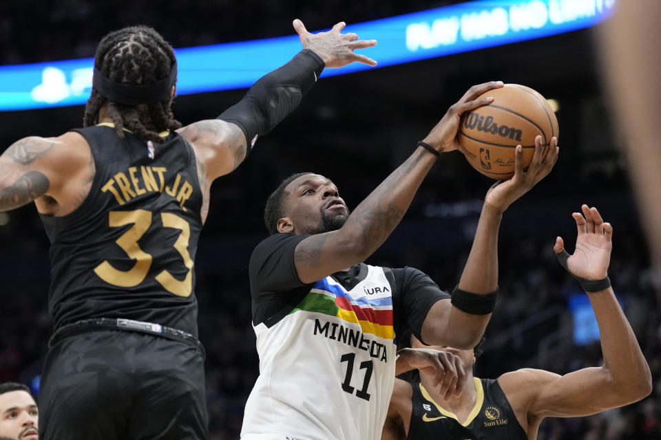 Minnesota Timberwolves center Naz Reid (11) goes for the basket under pressure from Toronto Raptors guard Gary Trent Jr. (33) during the second half of an NBA basketball game, in Toronto, Saturday, March 18, 2023. (Frank Gunn/The Canadian Press via AP)