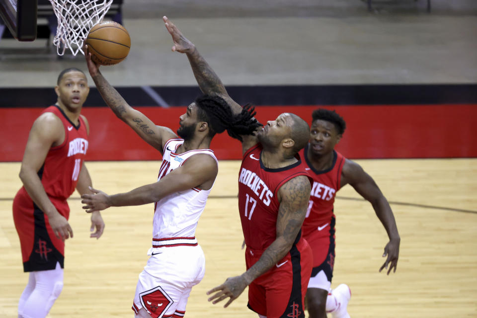 Chicago Bulls' Coby White, second from left, shoots a layup ahead of Houston Rockets' P.J. Tucker (17) during the third quarter of an NBA basketball game Monday, Feb. 22, 2021, in Houston. (Carmen Mandato/Pool Photo via AP)