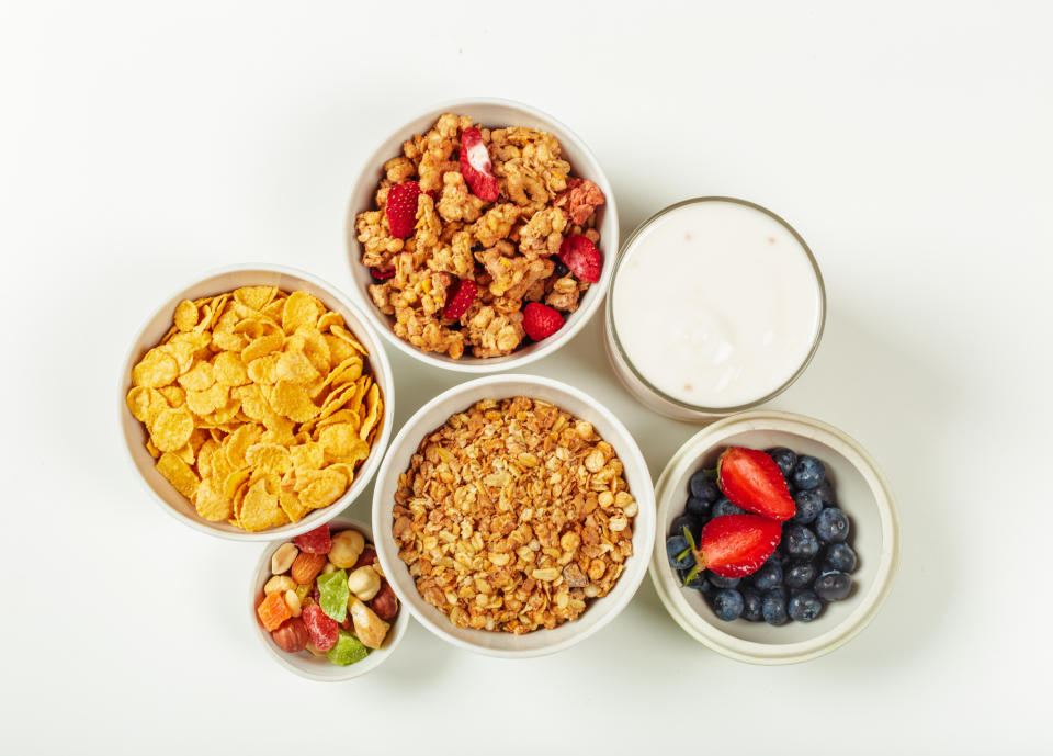 three bowls of cereal on a table with fruit