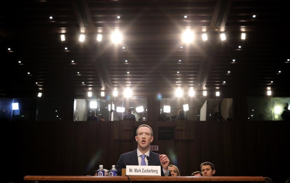 Mark Zuckerberg testifying in the Hart Senate Office Building in April 2010 over the Cambridge Analytica scandal. He is sitting in front of a plaque that has his name on it.