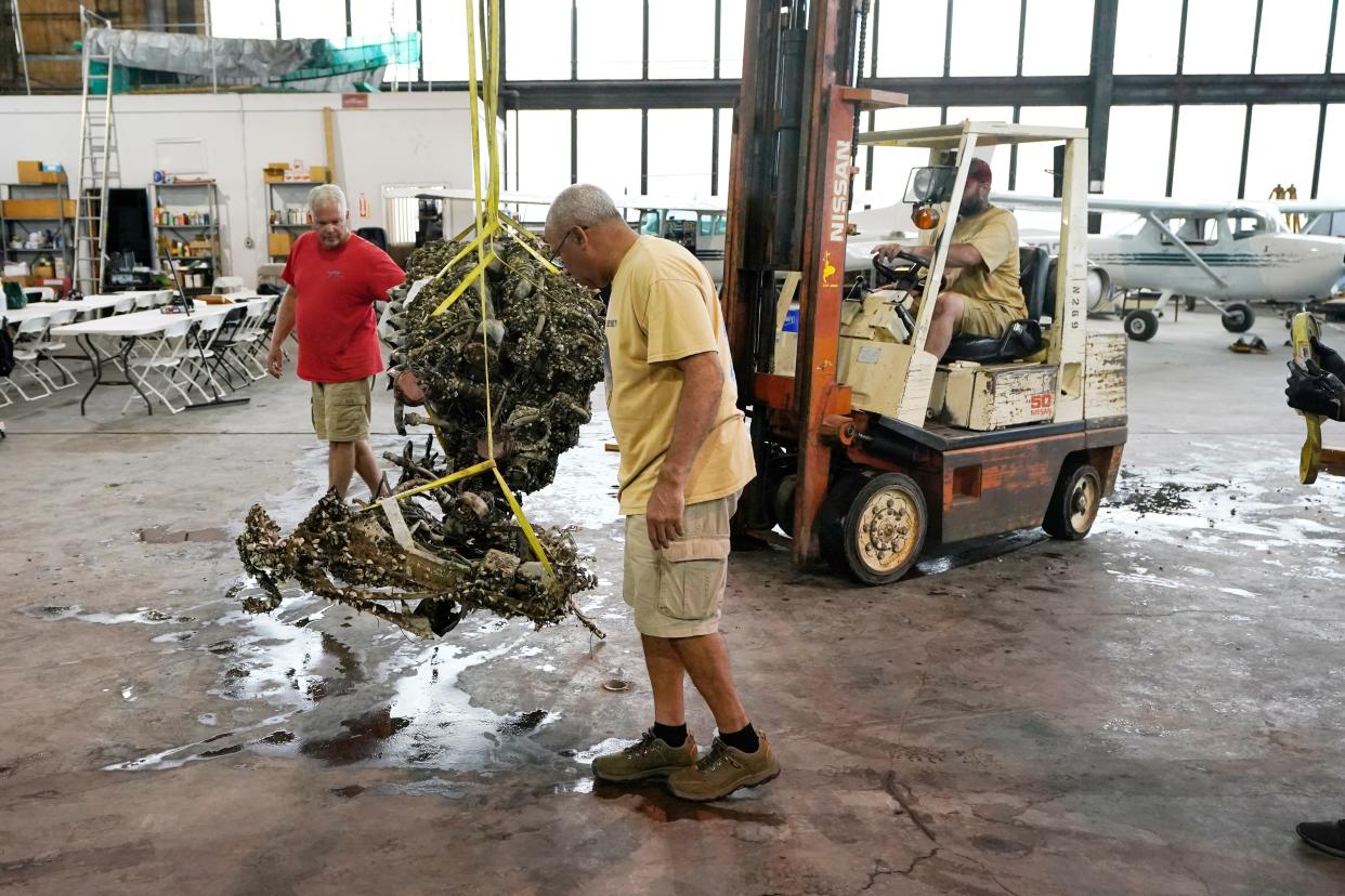 The 1,200-pound mussel-encrusted engine from a P-39 World War II-era fighter plane flown by a member of the famed Tuskegee airmen is moved, Thursday, Aug. 17, 2023 at the Tuskegee Airmen National Historical Museum in Detroit. The plane was flown by a member of the famed Tuskegee airmen that crashed during training nearly 80 years ago near Port Huron, about 60 miles northeast of Detroit. (AP Photo/Carlos Osorio)