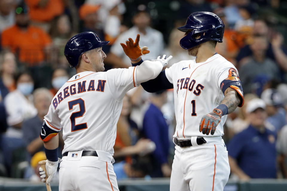 Houston Astros' Alex Bregman (2) and Carlos Correa (1) celebrate Correa's home run against the Los Angeles Angels during the first inning of a baseball game Saturday, April 24, 2021, in Houston. (AP Photo/Michael Wyke)