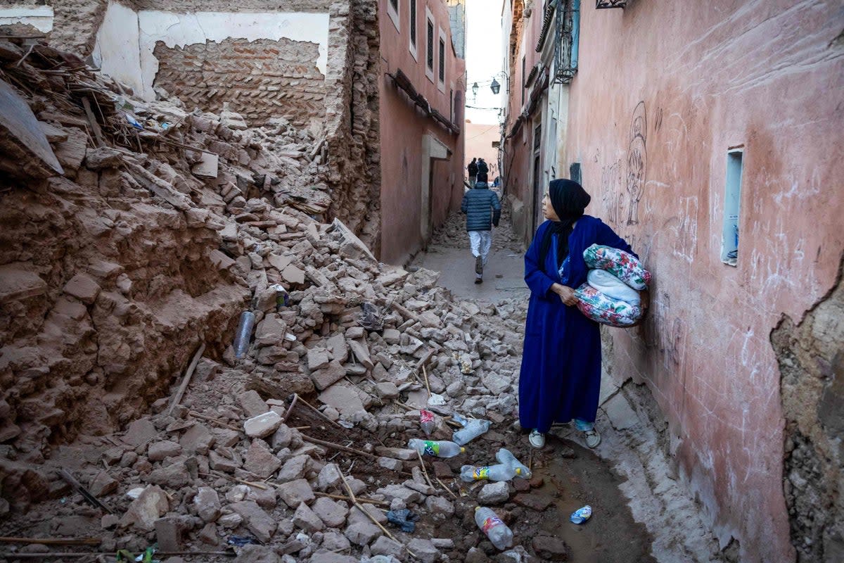 A woman looks at the rubble of a building in the earthquake-damaged old city in Marrakech (AFP via Getty Images)