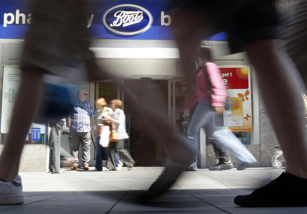 Pedestrians walk past a Boots branch in Leicester, central England June 9, 2008.  Britain's biggest pharmacy chain, Alliance Boots, posted a 20 percent rise in annual profit in its first year as a private company and said it was confident about its prospects despite a downturn in consumer spending.  Photograph taken on June 9, 2008.     REUTERS/Darren Staples   (BRITAIN)