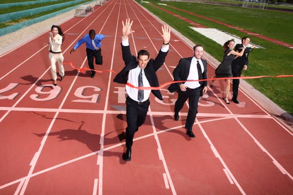 Businesspeople racing across a finish line.