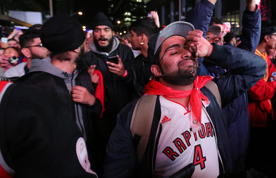 TORONTO, ON- JUNE 14 - A Toronto Raptors fan wipes a tear as Toronto fans celebrate in Jurassic Park after Toronto beat the Golden State Warriors in game six to win the NBA Championship at Oracle Arena in Oakland outside in Toronto. June 14, 2019. (Steve Russell/Toronto Star via Getty Images)