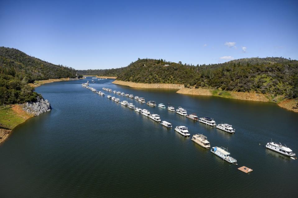 Houseboats float at Lake Oroville State Recreation Area on Sunday, March 26, 2023, in Butte County, Calif. Months of winter storms have replenished California’s key reservoirs after three years of punishing drought. (AP Photo/Noah Berger)