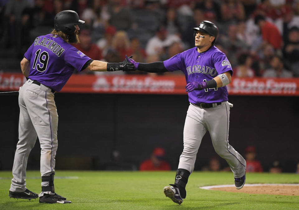 Colorado Rockies' Tony Wolters, right, is congratulated by Charlie Blackmon after hitting a solo home run during the third inning of a baseball game against the Los Angeles Angels, Monday, Aug. 27, 2018, in Anaheim, Calif. (AP Photo/Mark J. Terrill)