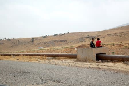 Boys sit on the Iraqi-Turkish pipeline in Zakho district of the Dohuk Governorate of the Iraqi Kurdistan province, Iraq, August 28, 2016. REUTERS/Ari Jalal