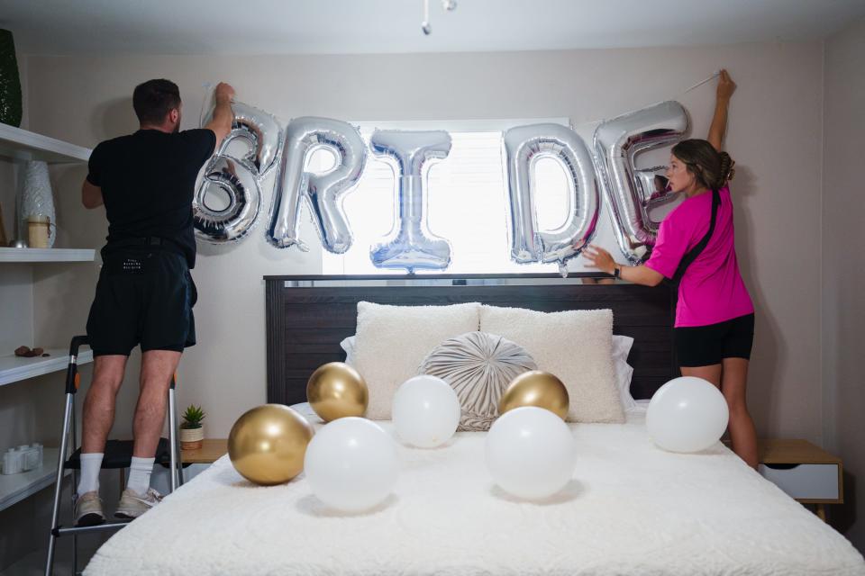 Casey Hohman, left, and Kelcie Thomas, right, decorate the bride's bed for a client's bachelorette party on July 7, 2022, in Scottsdale.