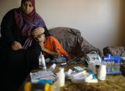 <p>Palestinian boy Mohammad Shanty, who suffers from cystic fibrosis, sits next to his mother after receiving oxygen therapy during a power cut in their family house, which is equipped with a backup battery-powered system, in Gaza City, July 2, 2017. (Photo: Mohammed Salem/Reuters) </p>