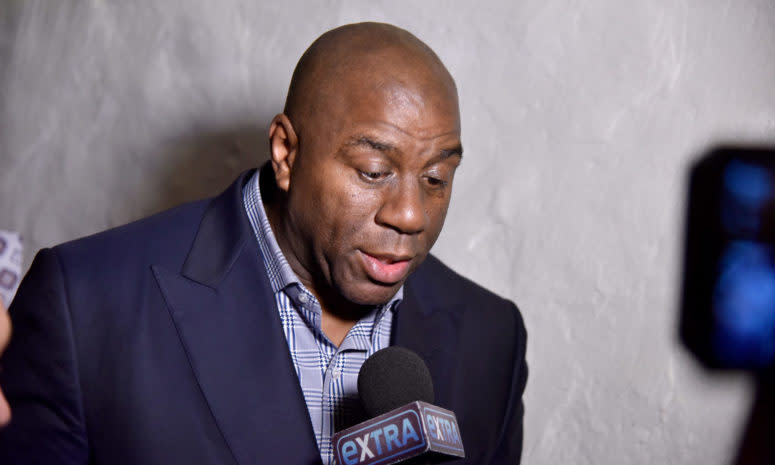 Magic Johnson speaks with reporters at an event.