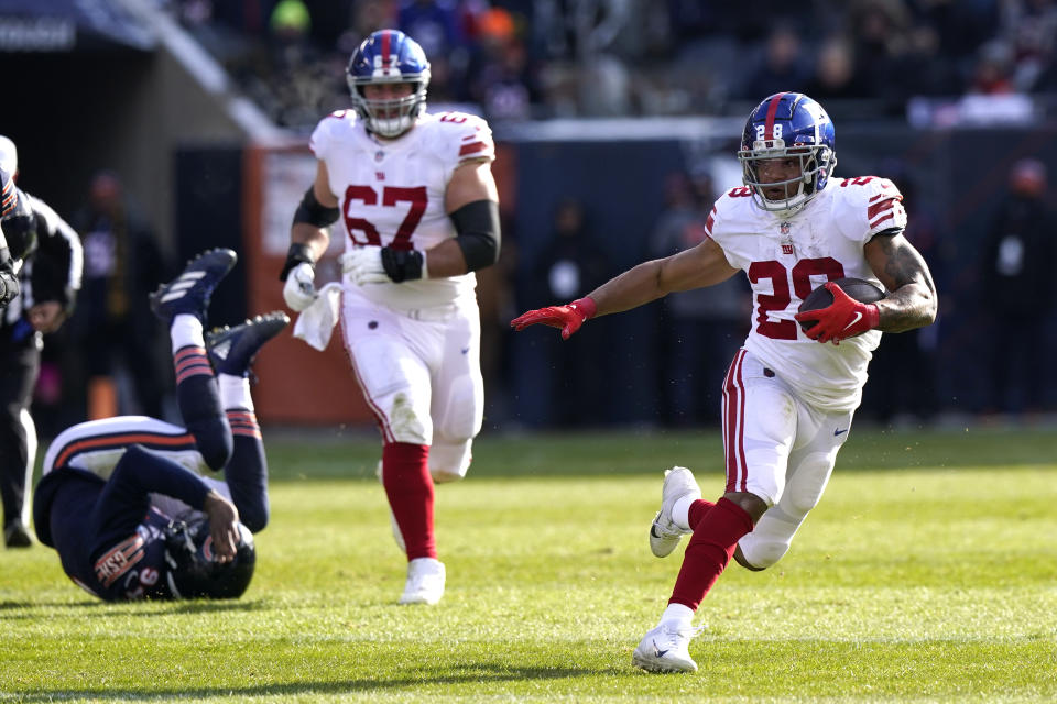 CORRECTS IDENTIFICATION TO DEVANTAE BOOKER New York Giants running back Devontae Booker (28) carries the ball as guard Matt Skura follows during the first half of an NFL football game against the Chicago Bears Sunday, Jan. 2, 2022, in Chicago. (AP Photo/Nam Y. Huh)