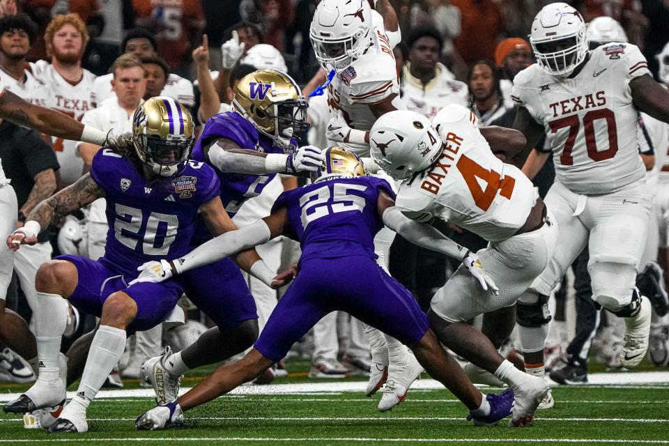 Texas running back CJ Baxter, right, pushes past Washington cornerback Elijah Jackson during Monday night's 37-31 loss in the Sugar Bowl. Baxter, like fellow running back Jaydon Blue, finished with more than 100 yards of total offense.