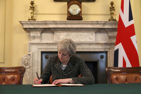 British Prime Minister Theresa May in the cabinet office signs the official letter to European Council President Donald Tusk invoking Article 50 and the United Kingdom's intention to leave the EU on March 28, 2017 in London, England. REUTERS/Christopher Furlong/Pool