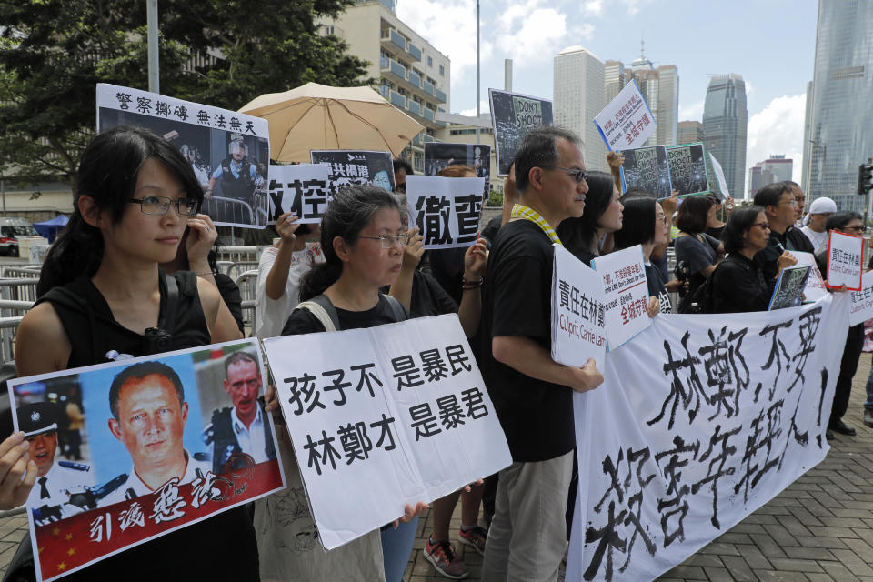 Activists from various groups including parents and religious hold placards of picture of police commander with Chinese reads "The child is not rioter, Carrie Lam is the tyrant", outside the government office demanding to stop shooting their kids in Hong Kong, Thursday, June 20, 2019. A Hong Kong student group demanded Wednesday that the city completely scrap a politically charged extradition bill and agree to investigate police tactics against protesters before a Thursday deadline or face further street demonstrations. (AP Photo/Kin Cheung)