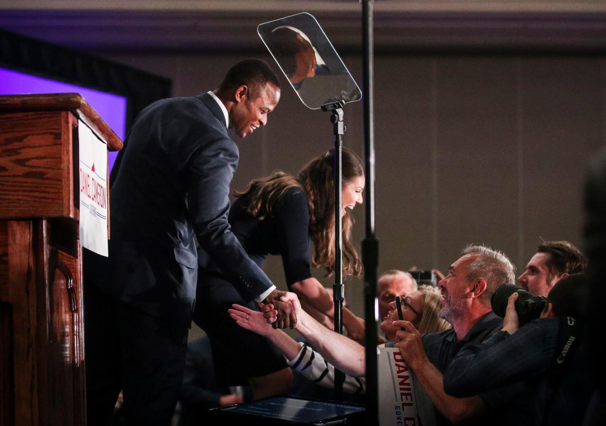 Kentucky Attorney General Daniel Cameron shakes hands with supporters alongside his wife Makenze after his win in the GOP gubernatorial primary in May 2023.