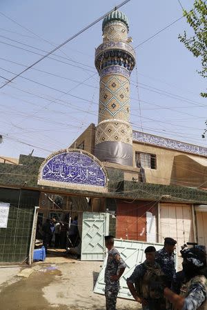 Iraqi security forces stand guard outside a Shi'ite mosque after a suicide bomb attack in the New Baghdad district, eastern Baghdad, August 25, 2014. REUTERS/Thaier al-Sudani