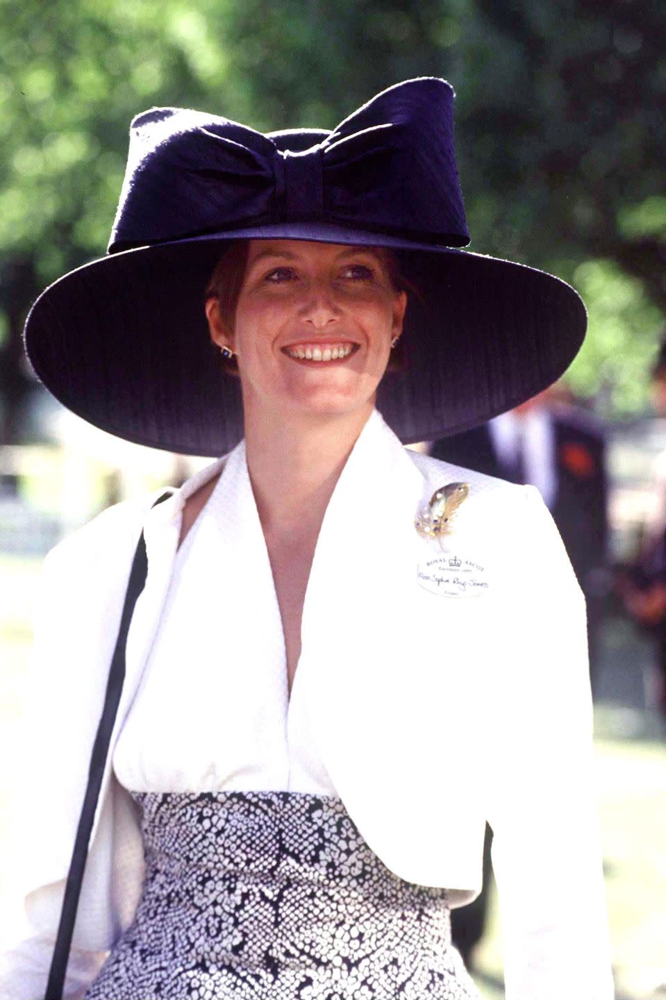<p>Sophie Rhys-Jones at the Royal Ascot Races in the 90s wearing white and an oversized black bow hat.</p>