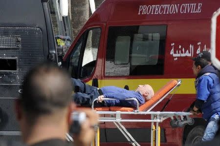 A tourist injured after an attack by gunmen on Tunisia's national museum is wheeled on a stretcher in Tunis March 18, 2015. REUTERS/Stringer