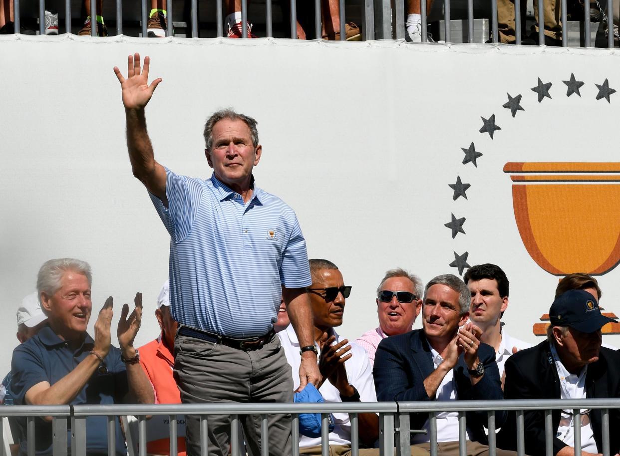 JERSEY CITY, NJ - SEPTEMBER 28: Former President George W. Bush (C) waves during the trophy presentation on the first tee as former Presidents Bill Clinton (L) and Barack Obama (3rd R) look on during the first round of the Presidents Cup at Liberty National Golf Club on September 28, 2017, in Jersey City, New Jersey. (Photo by Stan Badz/PGA TOUR)